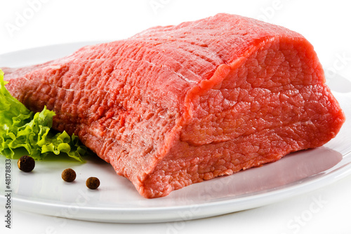 Photo: Raw beef and vegetables on white background Raw beef and vegetables on white background