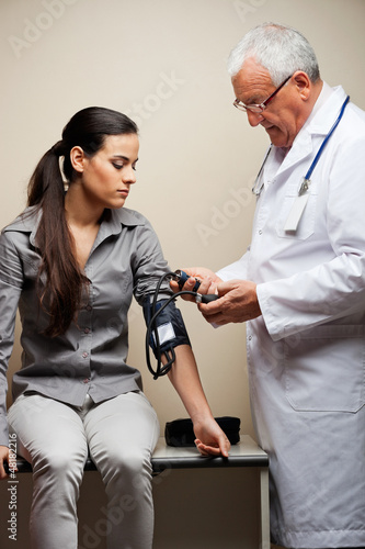 Photo: Doctor Taking Woman's Blood Pressure Doctor Taking Woman's Blood Pressure
