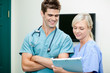 Young Female Nurse Showing Clipboard To Male Vet