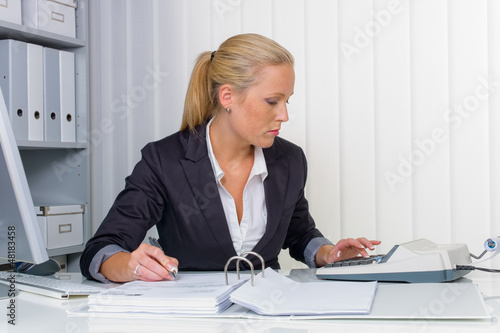 Photo: Frau im Büro mit Rechenmaschine Frau im Büro mit Rechenmaschine