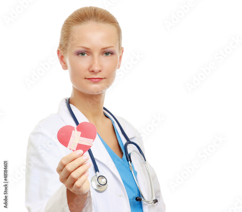 Photo: A female doctor holding a symbol of a heart which is repaired A female doctor holding a symbol of a heart which is repaired