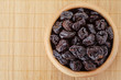Photo: Dried prunes in wooden bowl Dried prunes in wooden bowl