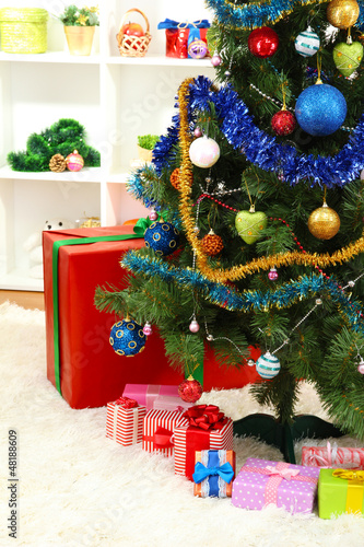 Photo: Decorated Christmas tree on home interior background Decorated Christmas tree on home interior background