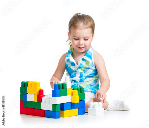 Photo: little cheerful child with construction set over white backgroun little cheerful child with construction set over white backgroun