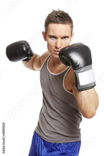 Photo: Muscular young man boxing in sports outfit Muscular young man boxing in sports outfit