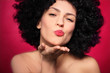 Woman with afro blowing a kiss