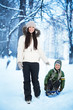 Mom is rolling her son on a sled