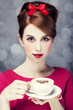 Redhead girl with coffee cup. St. Valentine Day.