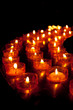 Viele Lichter vor schwarzem Hintergrund in einer Kirche