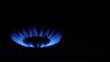 Gas stove flames ignition by match over dark background.