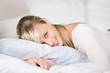 blonde frau liegt auf dem bett