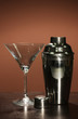 Cocktail shaker and cocktail glass on color background