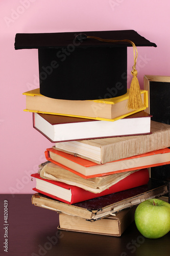 Photo: Books and magister cap against school board Books and magister cap against school board