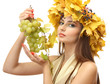 beautiful young woman with yellow autumn wreath and grapes,