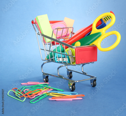 Photo: trolley with school equipment on blue background trolley with school equipment on blue background