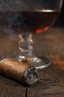 smoking cigar with a glass of brandy