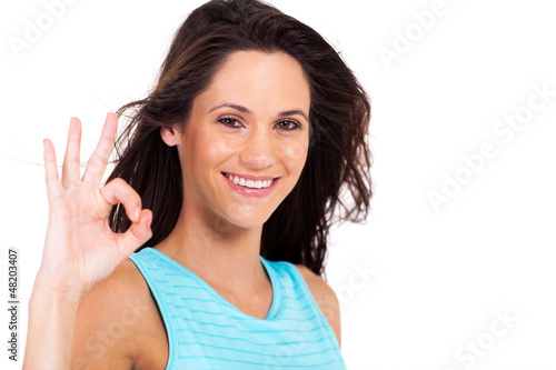 Photo: pretty young woman giving ok hand sign over white background pretty young woman giving ok hand sign over white background
