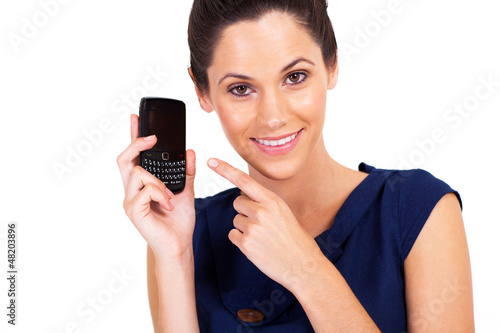 Photo: cute young woman pointing at smart phone isolated cute young woman pointing at smart phone isolated