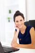 cheerful pretty woman sitting in front of laptop