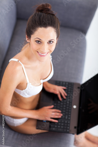 Photo: pretty young woman in underwear using laptop on sofa pretty young woman in underwear using laptop on sofa