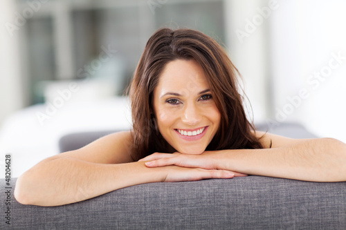 Photo: cheerful young woman lying on sofa laughing cheerful young woman lying on sofa laughing
