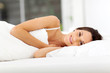 beautiful young woman smiling and sleeping on bed