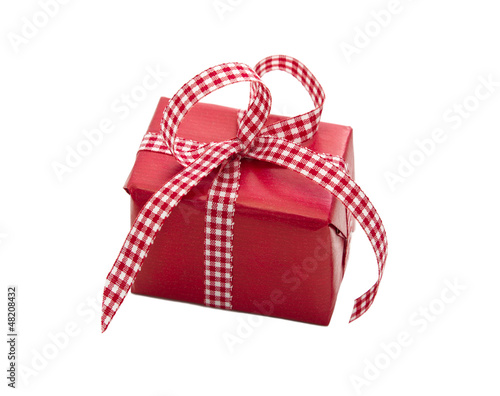 Photo: Rotes Geschenk mit rotweiß karierter Schleife isoliert Rotes Geschenk mit rotweiß karierter Schleife isoliert