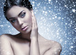 Portrait of a young and naked woman on a snowy background