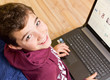 Foto: Freundlicher Junge - Kind mit Notebook - Laptop auf dem Schoß Freundlicher Junge - Kind mit Notebook - Laptop auf dem Schoß