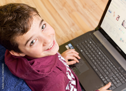 Photo: Freundlicher Junge - Kind mit Notebook - Laptop auf dem Schoß Freundlicher Junge - Kind mit Notebook - Laptop auf dem Schoß