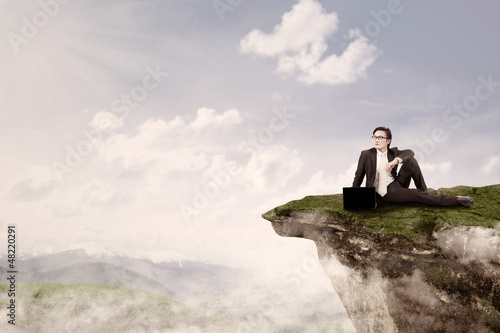 Photo: Businessman sit on top of mountain Businessman sit on top of mountain
