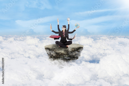 Photo: Businesswoman multitasking above clouds Businesswoman multitasking above clouds