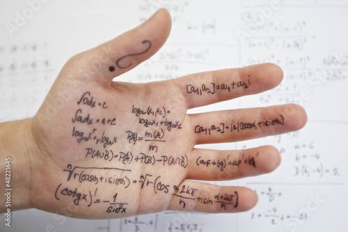 Photo: Hand of student with cheat sheet for math exam Hand of student with cheat sheet for math exam