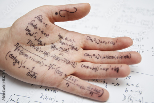 Photo: Hand of student with cheat sheet for math exam Hand of student with cheat sheet for math exam