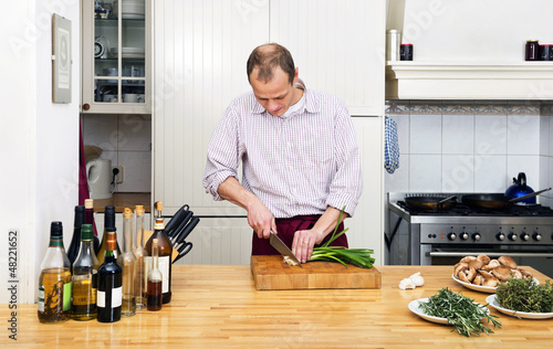 Photo: Man Cutting Spring Onions In Kitchen Man Cutting Spring Onions In Kitchen