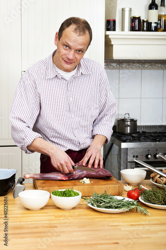 Photo: Man Preparing Meat At Kitchen Counter Man Preparing Meat At Kitchen Counter