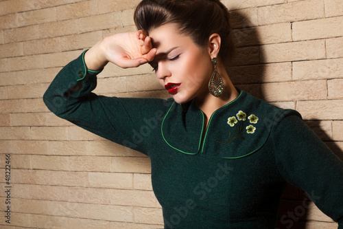 Photo: Aristocratic Brown Hair Sad Woman in Green Dress over Brick Wall Aristocratic Brown Hair Sad Woman in Green Dress over Brick Wall