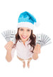 Foto: Woman in Santa hat holding money Woman in Santa hat holding money