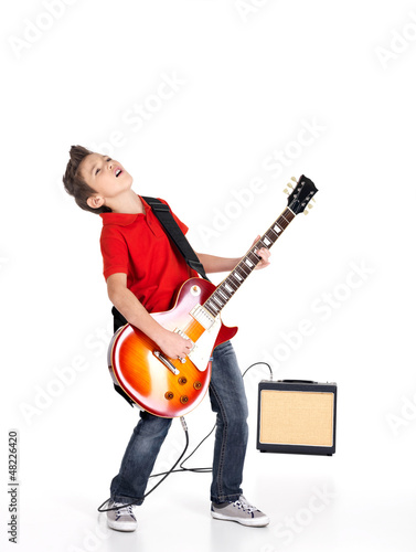 Photo: boy sings and plays on the electric guitar boy sings and plays on the electric guitar