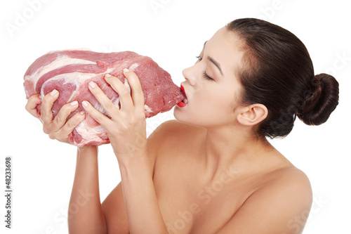 Photo: Young beautiful woman eating raw meat. Young beautiful woman eating raw meat.