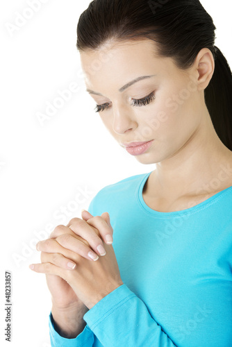 Photo: Closeup portrait of a young caucasian woman praying Closeup portrait of a young caucasian woman praying