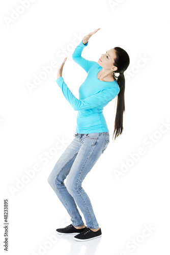 Photo: Scared young woman afraid of something above her Scared young woman afraid of something above her