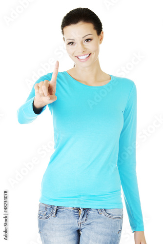 Photo: Young woman making choose on abstract screen Young woman making choose on abstract screen