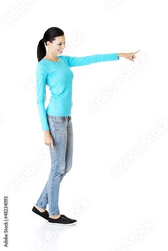 Photo: Happy , excited young woman pointing on copy space Happy , excited young woman pointing on copy space