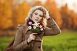 Young woman with a flowers in autumn field