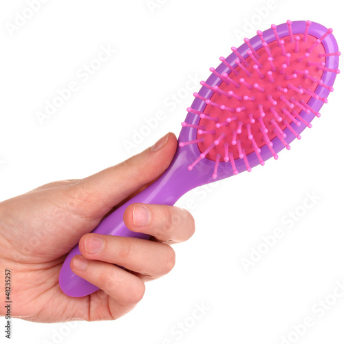 Photo: purple hair brush in the hand isolated on white purple hair brush in the hand isolated on white