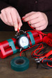 Human makes timebomb on wooden table on black background