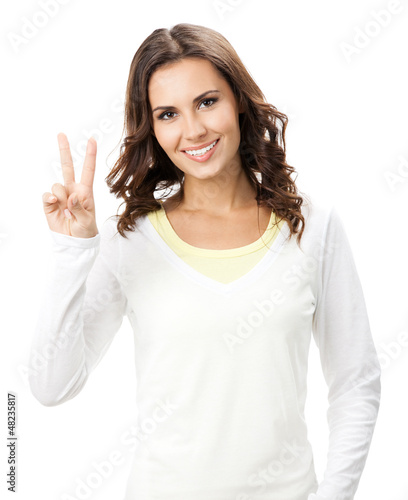 Photo: Woman showing two fingers or victory gesture, on white Woman showing two fingers or victory gesture, on white
