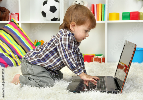 Photo: cute little boy and notebook in room cute little boy and notebook in room