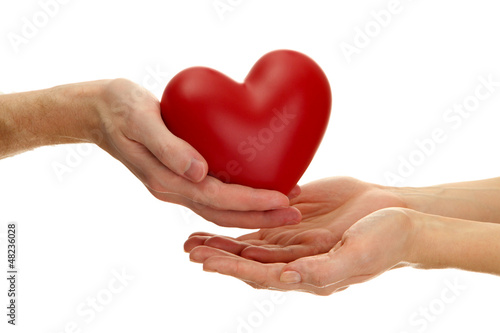 Photo: Red heart in woman and man hands, isolated on white Red heart in woman and man hands, isolated on white